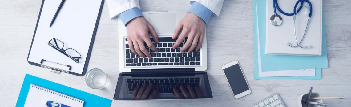 Doctor working on desk with computer